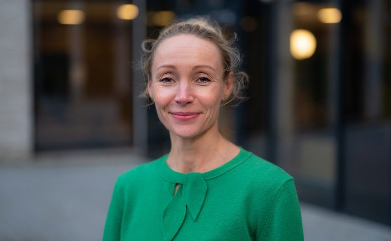 Dette bildet er en lenke til artikkel om hvordan din arbeidsplass kan bruke ekspertbistand. Bildet er av Karina Dokken, en ansatt i Arbeids- og velferdsdirektoratet. Hun har lyst hår og grønn genser. Foto.